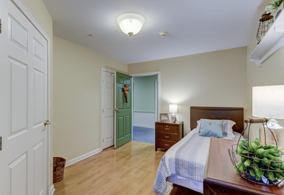 A well-furnished resident room with a bed and decor