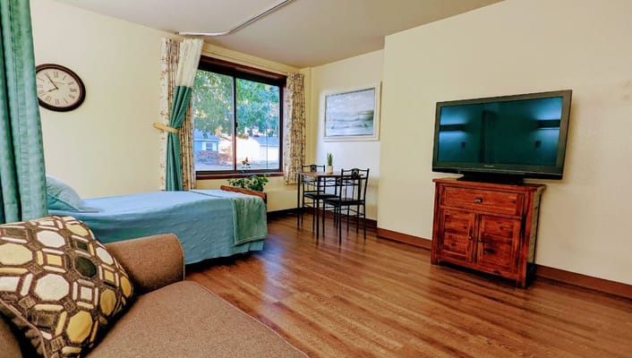 A cozy resident room with a bed and seating area