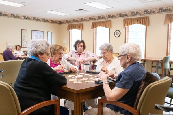 Residents enjoying a game in a bright common area