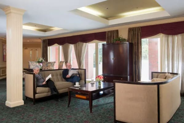 Two residents reading in a comfortable living room.