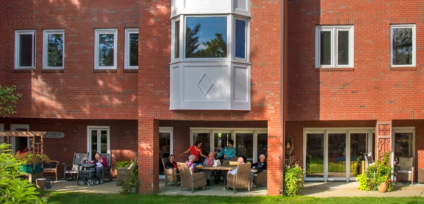 Group of residents socializing on the patio of Aynsley Place