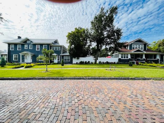 Two buildings featuring distinct architectural styles and lush greenery in front