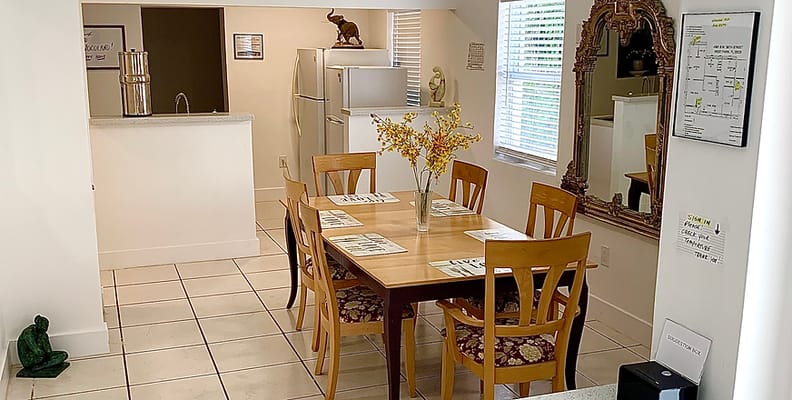 A bright dining area with a table and mirrors
