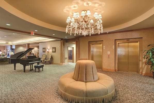 Spacious lobby with piano, chandelier, and seating area