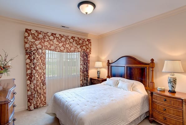 Well-decorated bedroom with floral curtains and wooden furniture