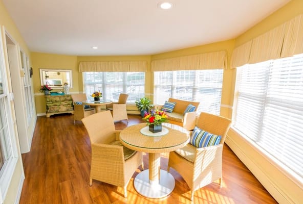 Bright sunroom with comfortable seating and flowers