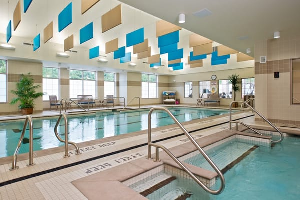 Indoor pool area with seating and natural light