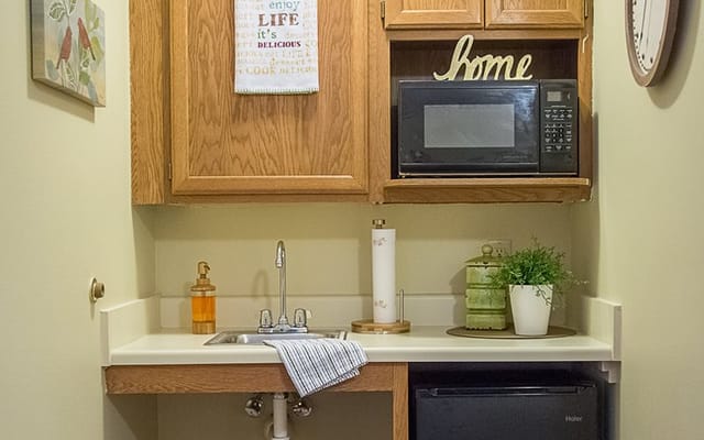 Cozy kitchenette with microwave, sink, and decor