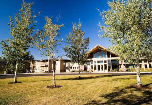 Exterior view of a senior living facility with trees in foreground
