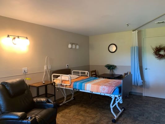 A simple resident room with a bed and chair