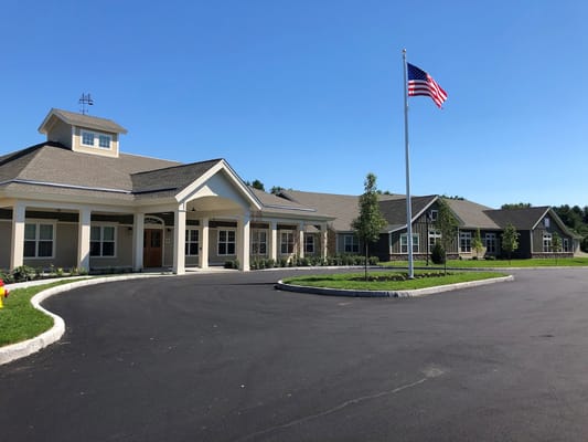 Exterior view of a senior living facility with flag