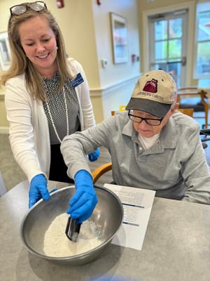 Resident and staff member engaging in baking activity