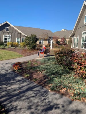 A resident enjoying a garden path bench