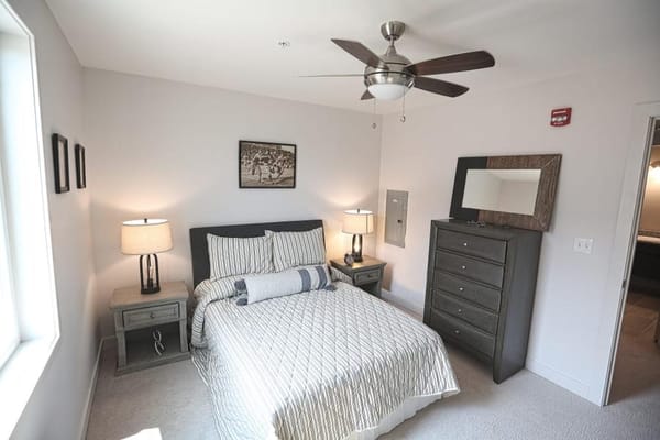 A well-decorated private resident room with a bed and dresser