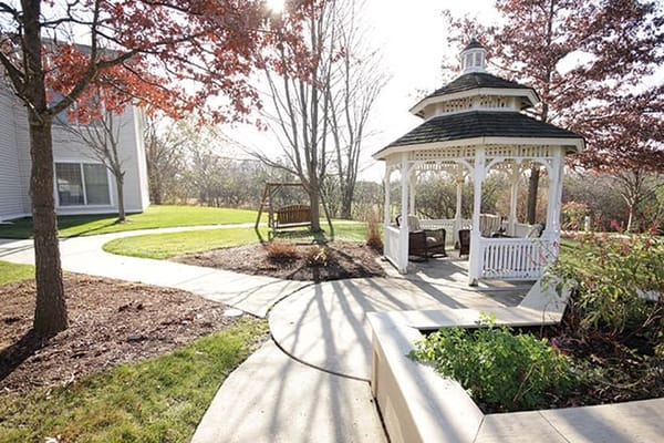 White gazebo surrounded by landscaped grounds
