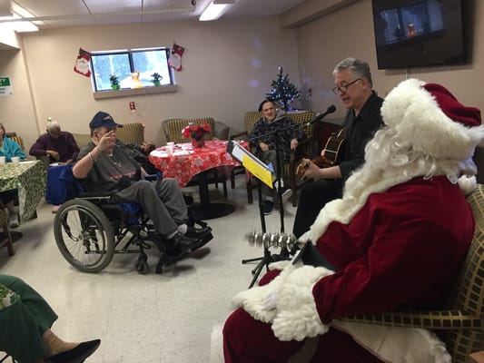Residents enjoying live music performance with Santa