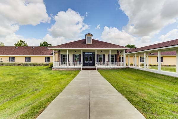 Front view of the Camelot Rehabilitation facility with a pathway and grassy area