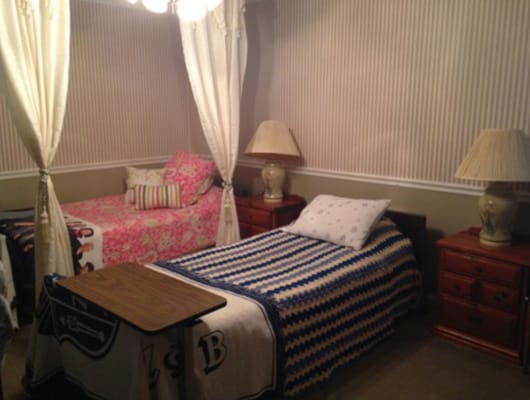 A shared resident room with two beds and lamps