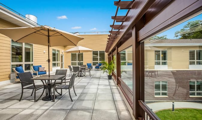 Patio area with tables and umbrellas at Cascade Creek Memory Care