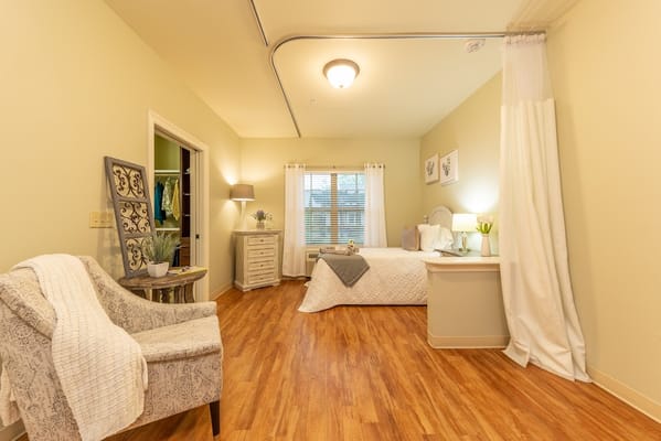Bright and inviting bedroom with wooden flooring and soft furnishings.