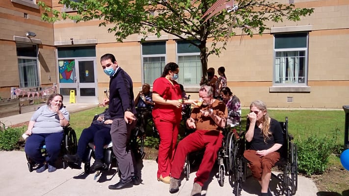 Residents enjoying an outdoor activity with staff assistance