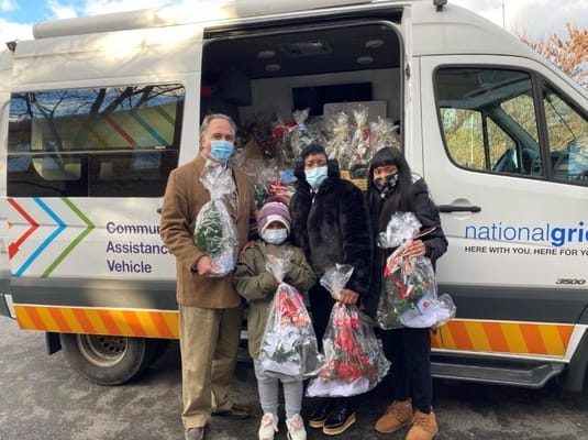 Community Assistance Vehicle with staff and children holding flowers