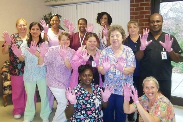 Staff members wearing pink gloves in a common area
