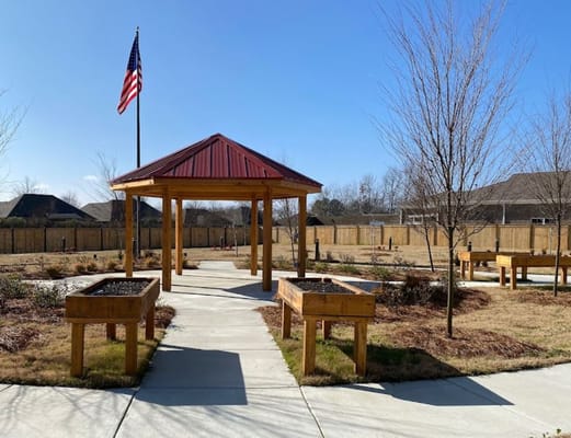 Wooden gazebo and raised garden beds in an outdoor space