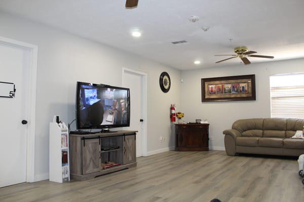 Living room with a television, seating, and artwork