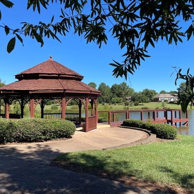 Gazebo overlooking a serene lake with greenery