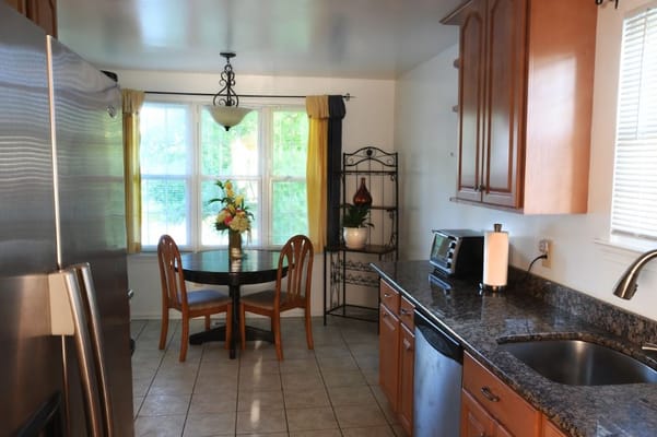 A well-lit kitchen area with a dining table and flowers