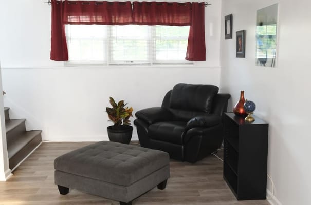 A cozy lounge area with a black recliner and ottoman