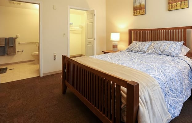 A private resident room with a bed and artwork on the wall