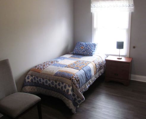 Cozy private room with a bed and side table
