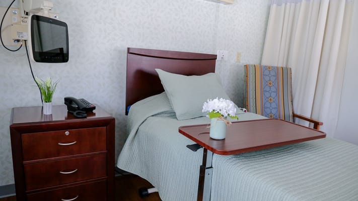 A cozy resident room with a bed and a nightstand