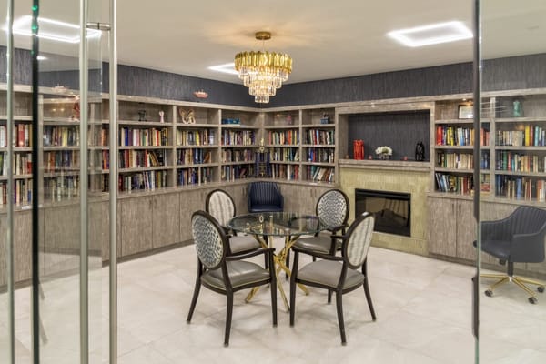 Elegant common area with bookshelves and a glass table
