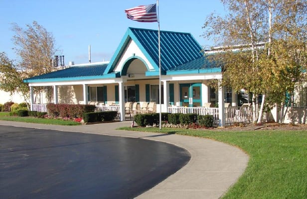Exterior view of the entrance with a blue roof and American flag.