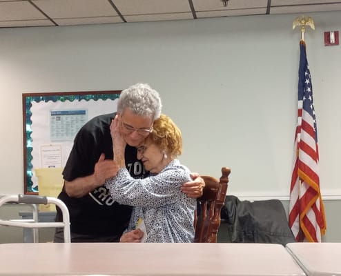 Two seniors embracing each other in a warm moment.