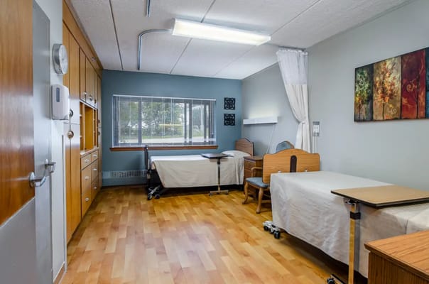 A shared resident room with two beds and furnishings