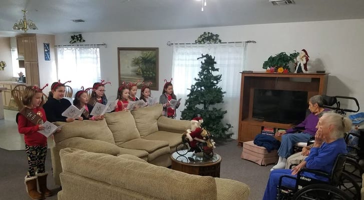 Children caroling for residents in a cozy living area