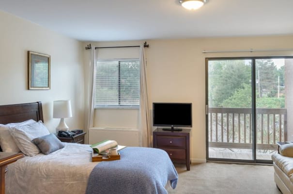 A cozy resident room with a bed and TV.