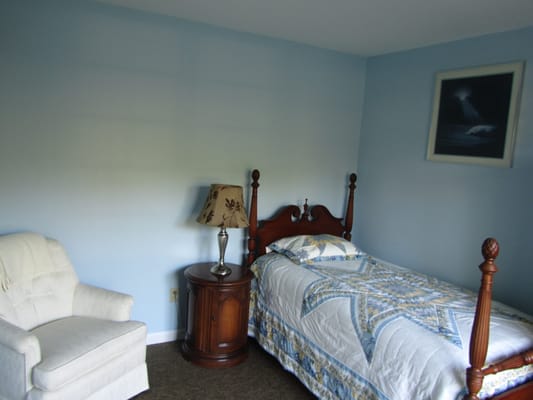 Cozy private resident room with a bed and armchair