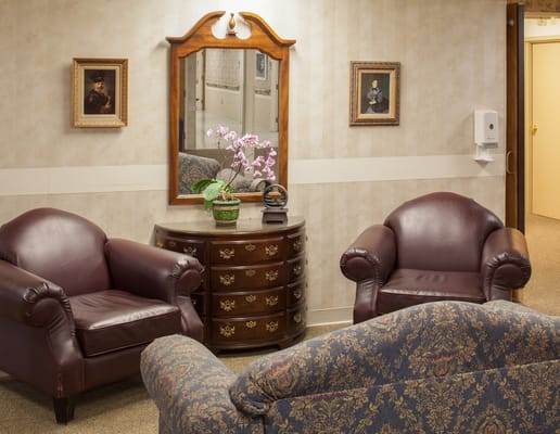 Lounge area with brown leather chairs and a decorative mirror