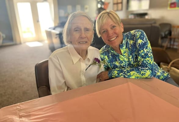 Resident and staff member smiling together in a common area