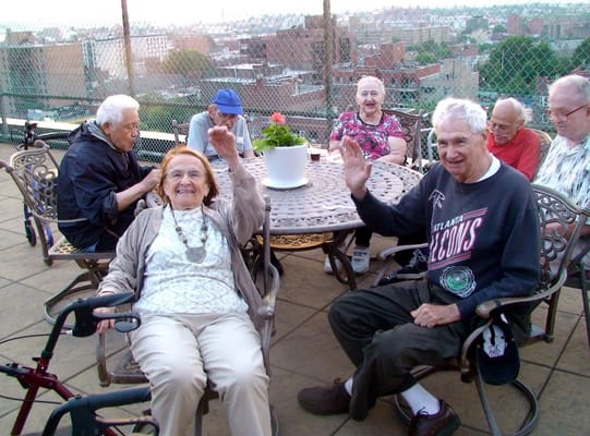 Residents in an outdoor area waving and socializing