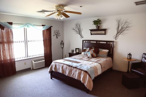 Cozy bedroom with a bed, decorative pillows, and window with curtains.