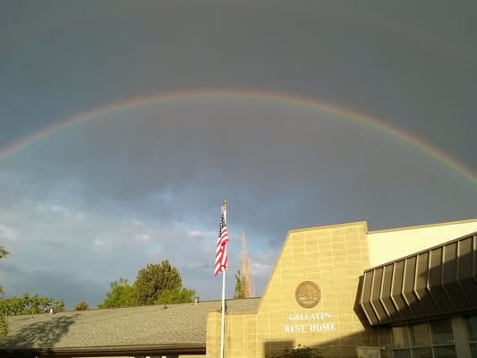 Exterior view of Gallatin Rest Home with a rainbow