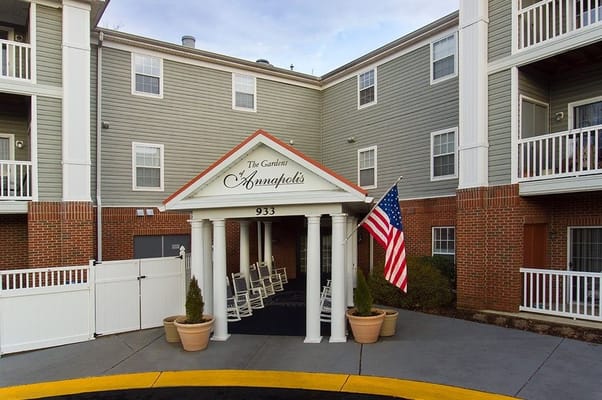 Entrance of Gardens of Annapolis with rocking chairs and flag