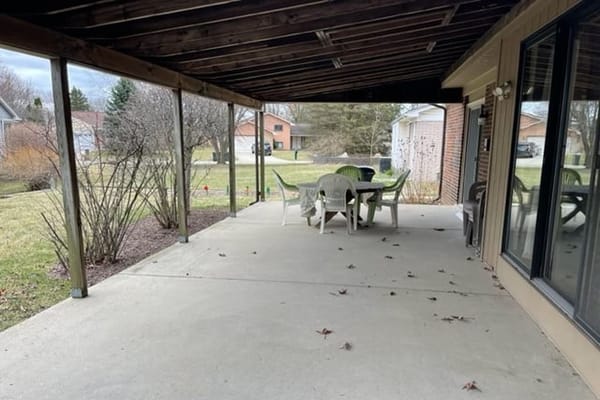 Covered patio with chairs and tables at Genesis Senior Living
