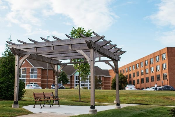 Wooden pergola with bench in the garden area of Glacier Hills.